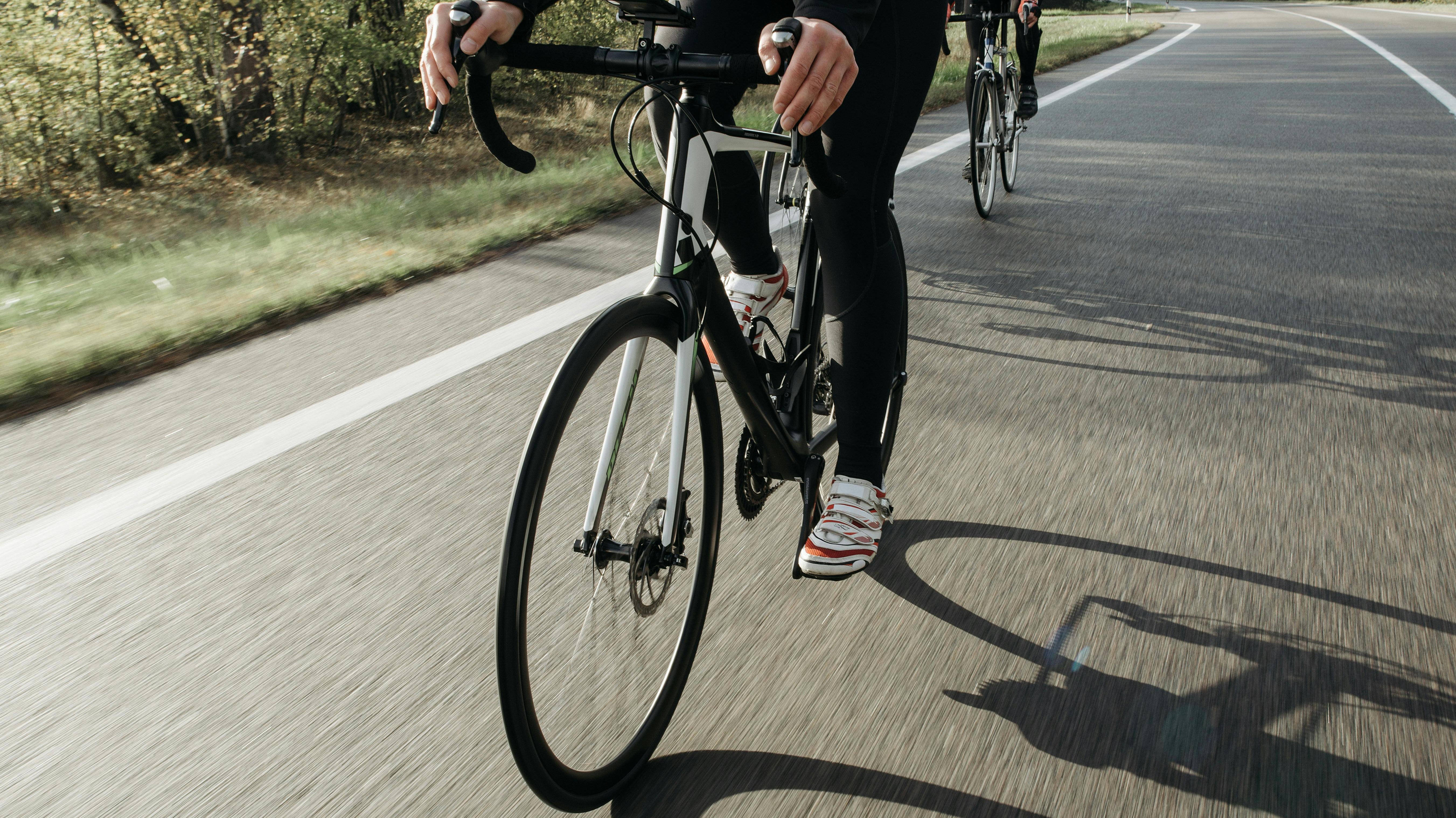 two people riding road bikes on a road