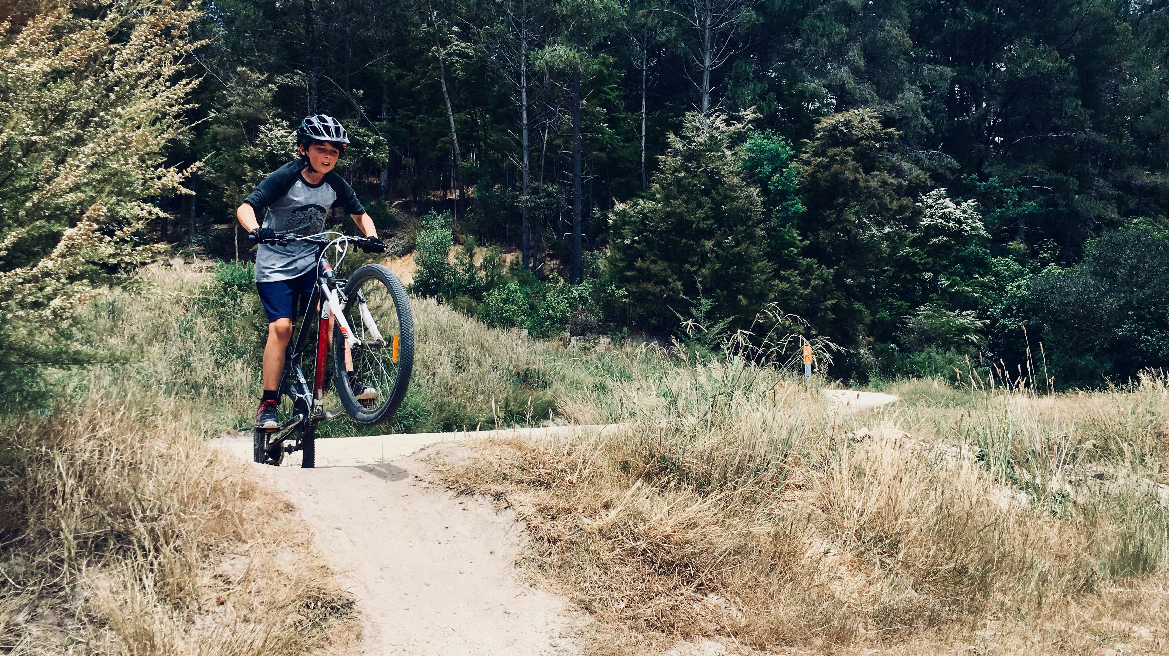 boy riding bicycle in forest