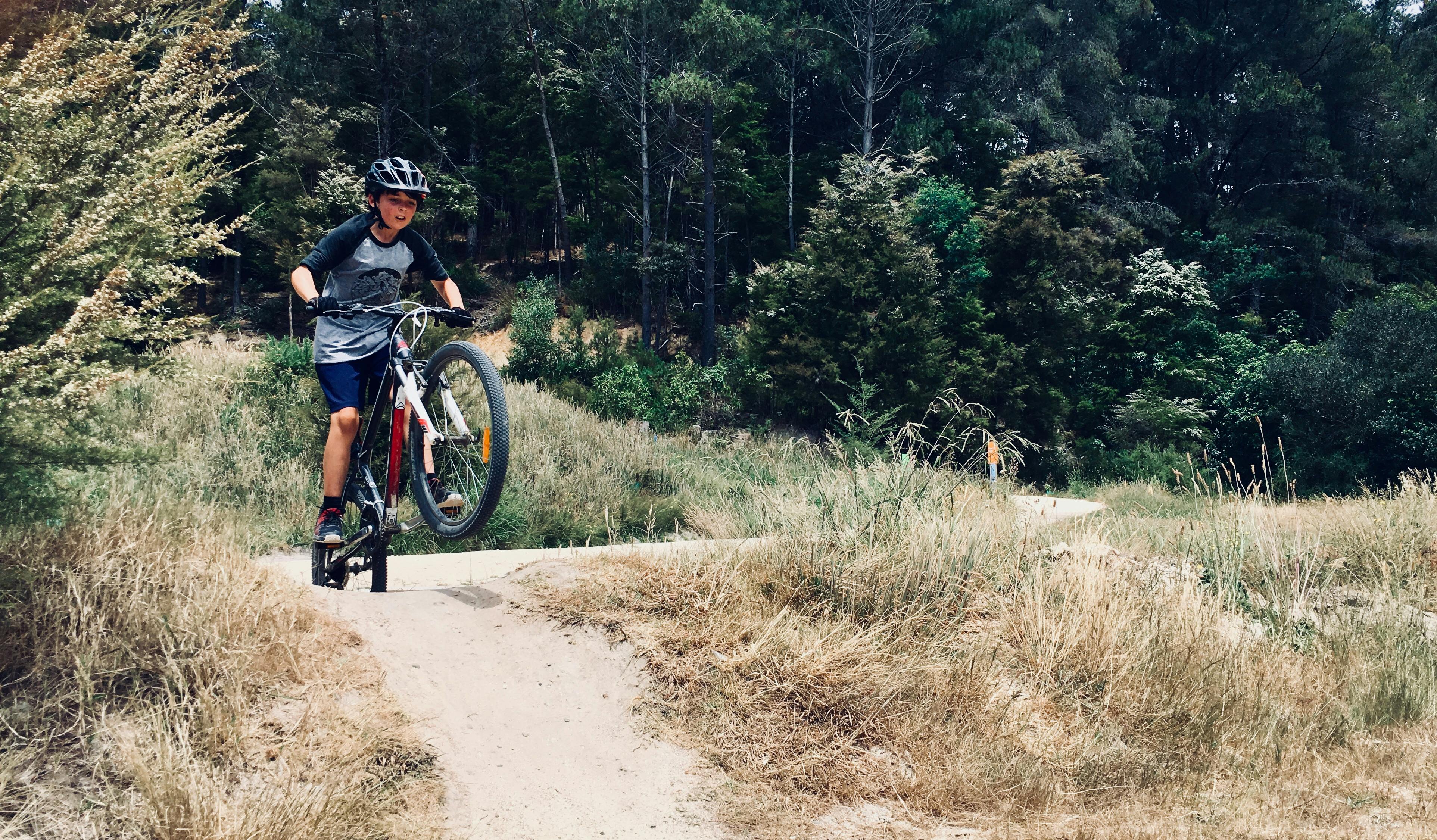 boy riding bicycle in forest